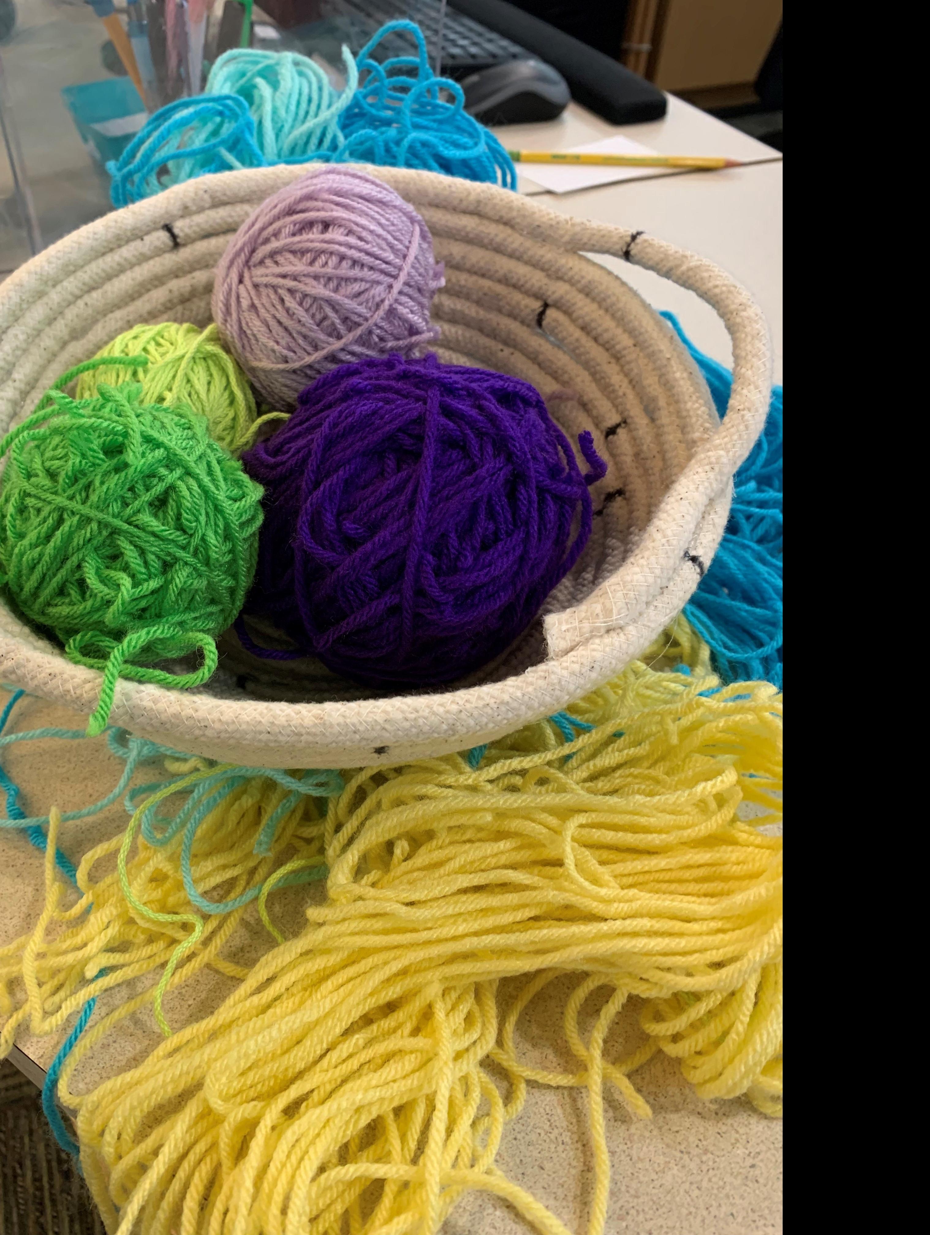 off white basket filled with yarn balls